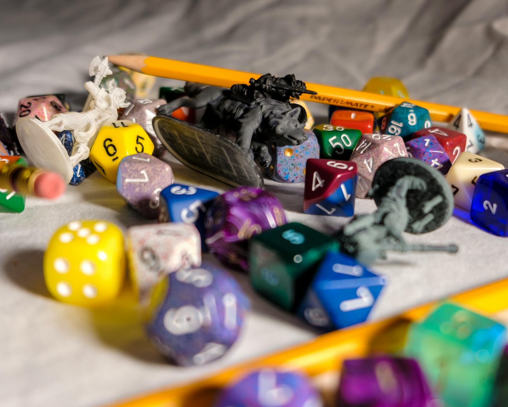 set of colorful dices on desk with pencils and toys